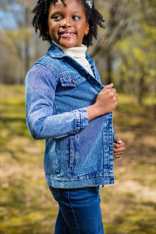 long blue denim jacket worn by a girl outdoors, showcasing its style and comfort.