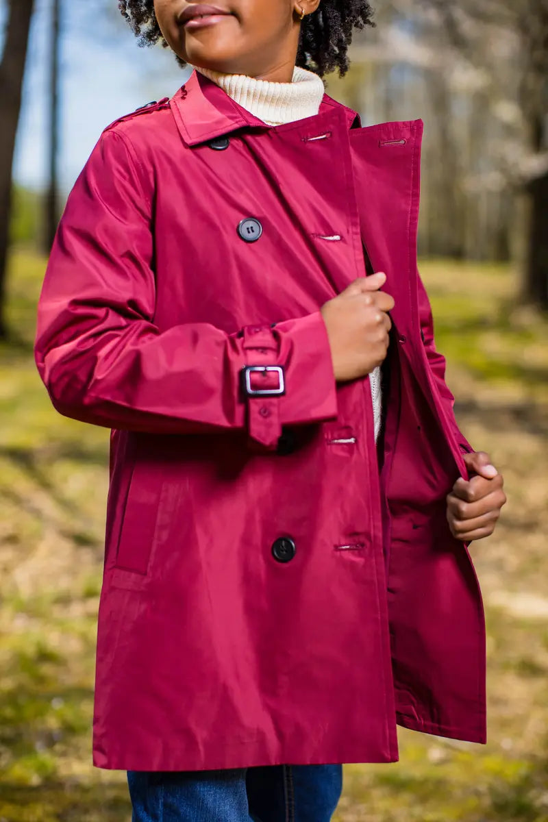 rich berry trench coat model showcasing style and elegance in a natural outdoor setting.