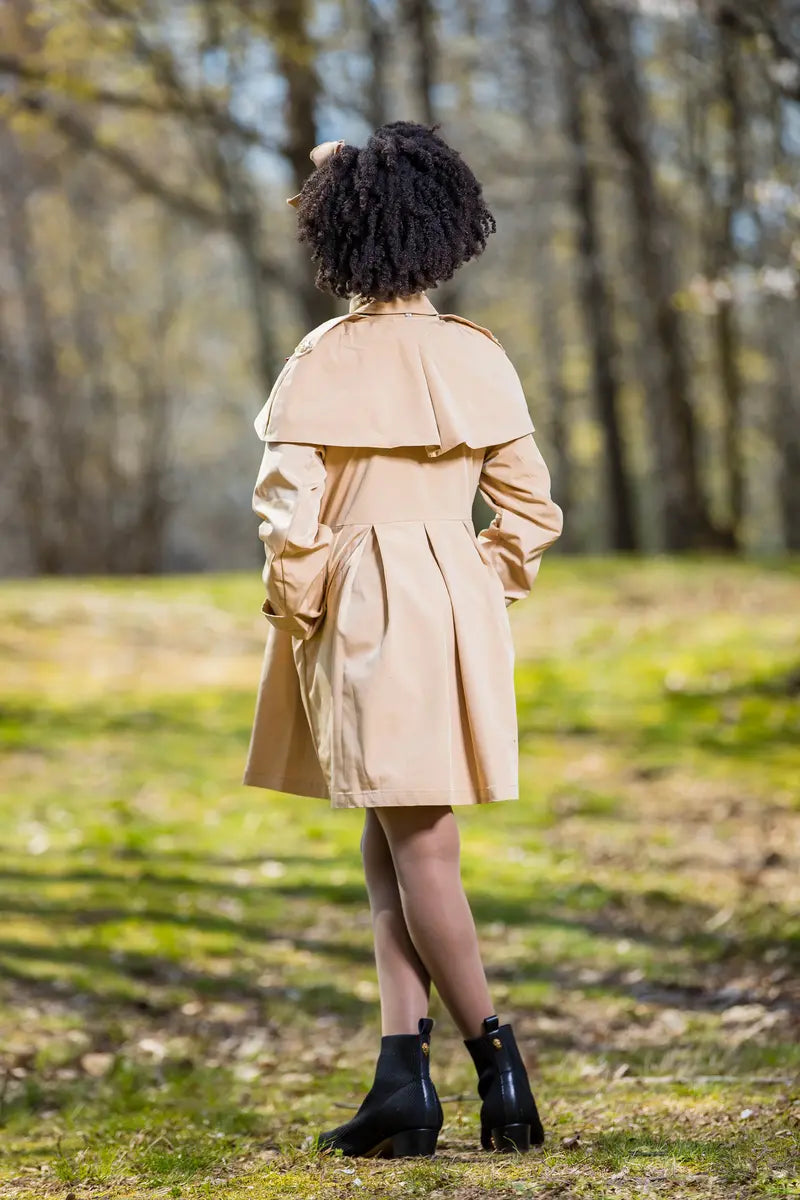 Back view of a model wearing a checkered ribbon trench coat in a natural setting at Yotty Boutiik.