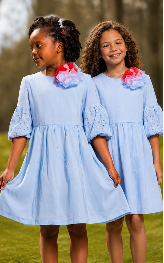 Two girls wearing elegant light blue a-line dresses with floral accents outdoors, perfect for spring and summer events.
